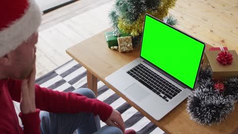 Caucasian-man-in-santa-hat-making-laptop-christmas-video-call,-with-green-screen-copy-space