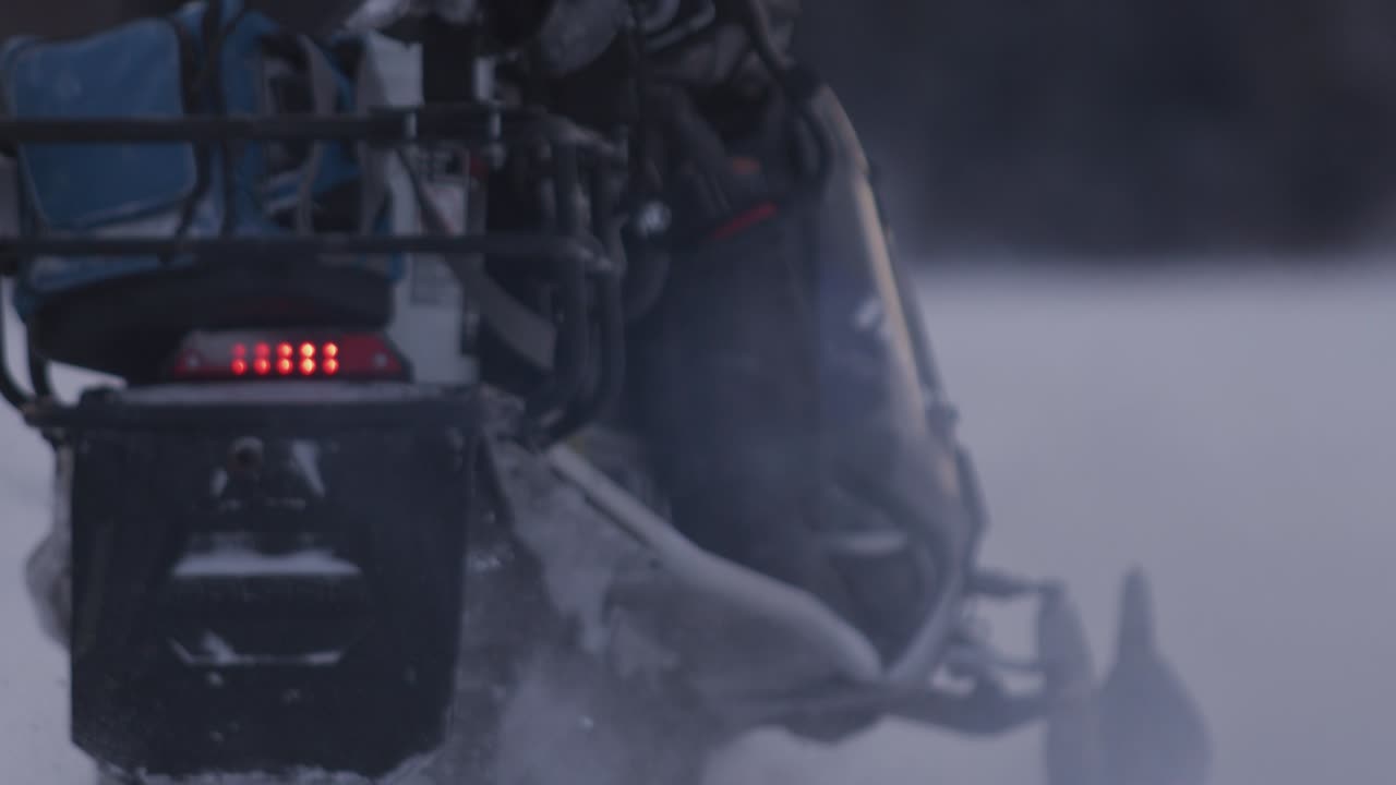 2 motos de nieve que se alejan en un lago congelado