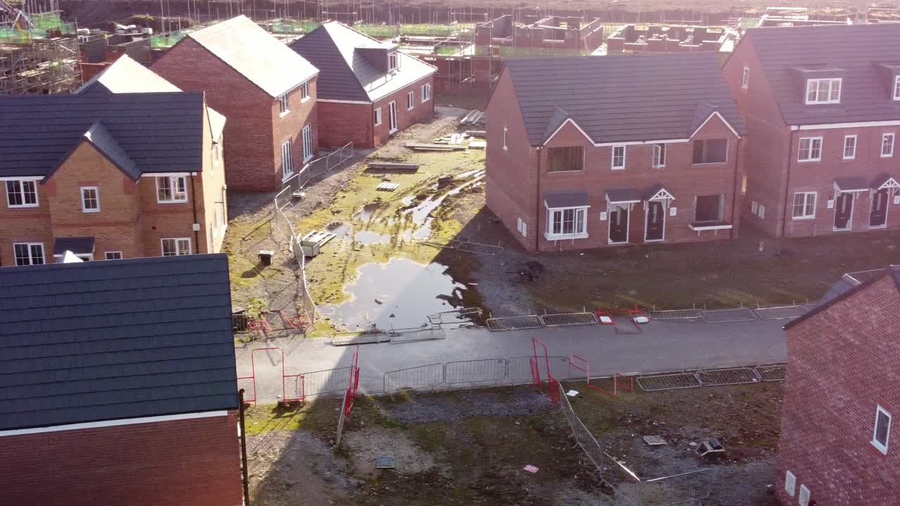 Abandoned townhouse property development construction site aerial view dolly left