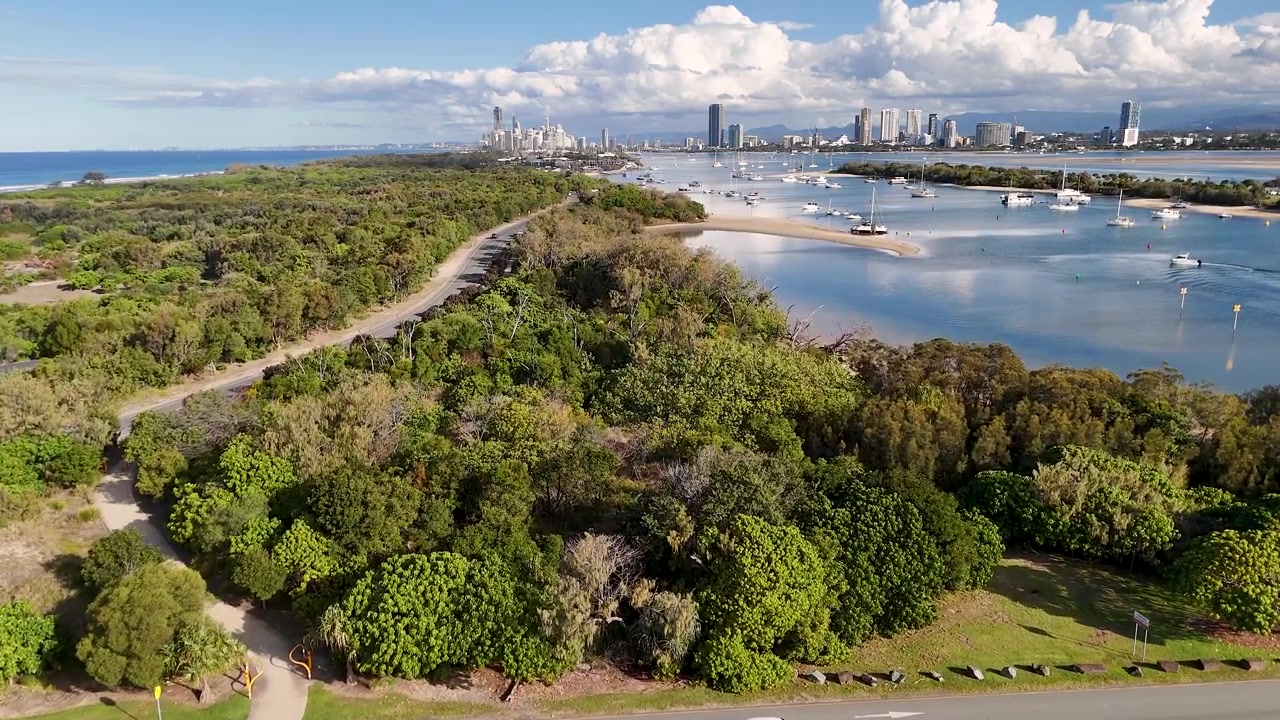 Il filmato del drone rivela il parco costiero, il corso d'acqua e lo skyline cittadino distante a Main Beach, Queensland.