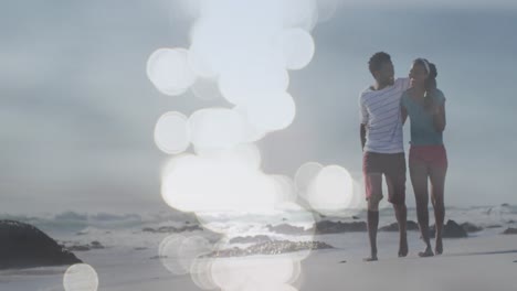 animación de puntos sobre una feliz pareja afroamericana caminando por la playa
