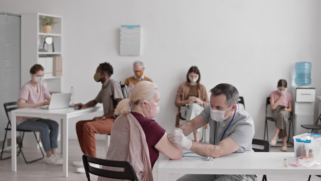Giving Vaccine Shot in Busy Hospital