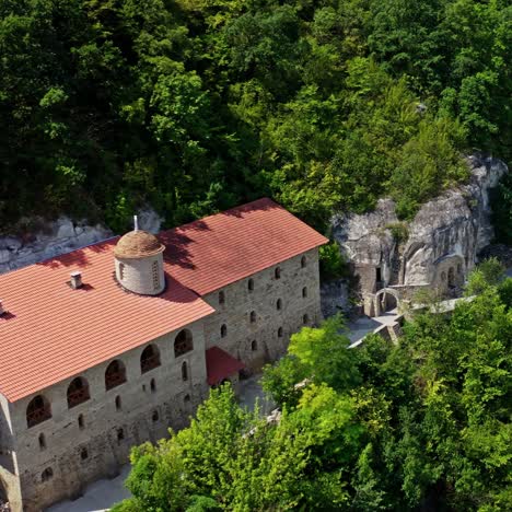 beautiful buildings in the mountains. stone architecture on the hill among green nature in summer. camera moving down.