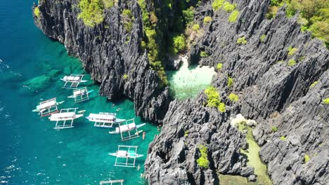 philippines coastline drone aerial view. secret beach and double outrigger boats in el nido, palawan island archipelago
