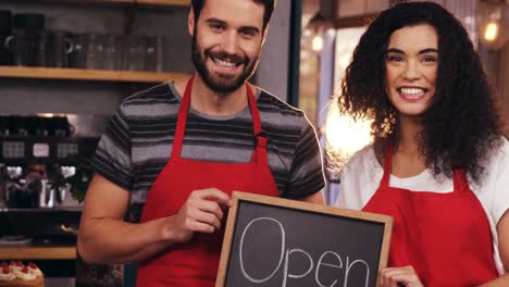 Waiter-and-waitress-showing-slate-with-open-sign