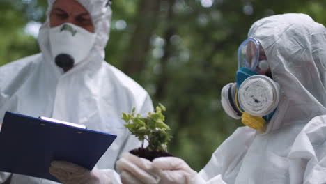 scientists examining plant life in protective suits