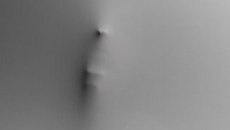 a creepy silhouette of a woman's face appears screaming from the white surface
