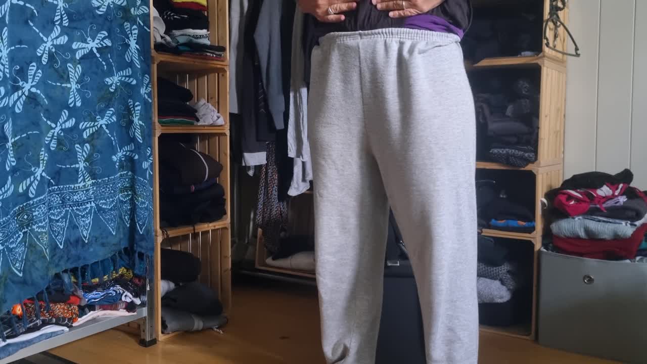 A woman changes into her trainer trousers to feel more comfortable at home, capturing a casual lifestyle moment in a relaxed domestic setting, Switzerland