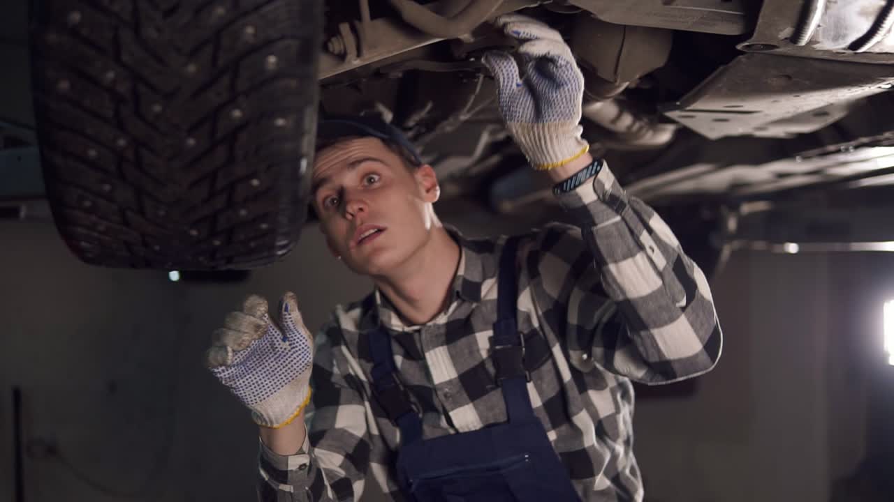 un guapo mecánico que pone mucho esfuerzo en arreglar todos los problemas del coche. servicio de coches, reparación, mantenimiento y concepto de personas.