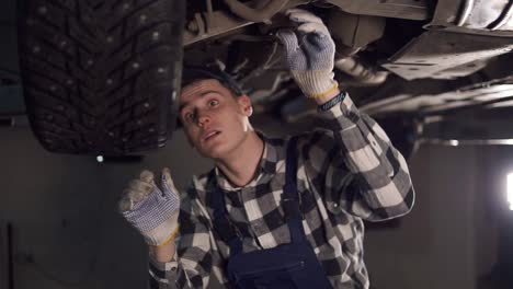 handsome mechanic putting a lot of effort into fixing all the car problems. car service, repair, maintenance and people concept.