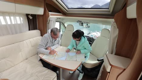 couples in rv camper looking at the local map for the trip.