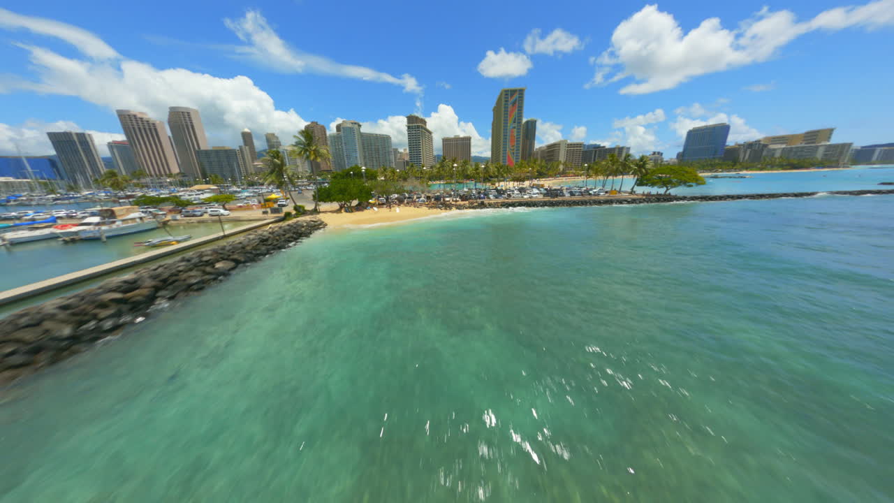 Volando verso la città di Honolulu, sopra lo splendido oceano blu scintillante e la spiaggia di Waikiki, drone FPV