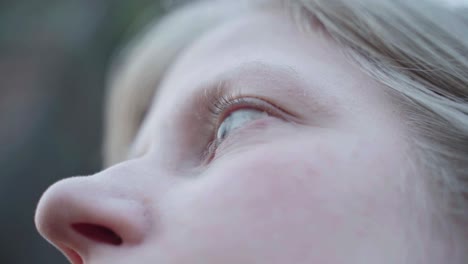 close up view of young blonde woman in her twenties stares and blinking