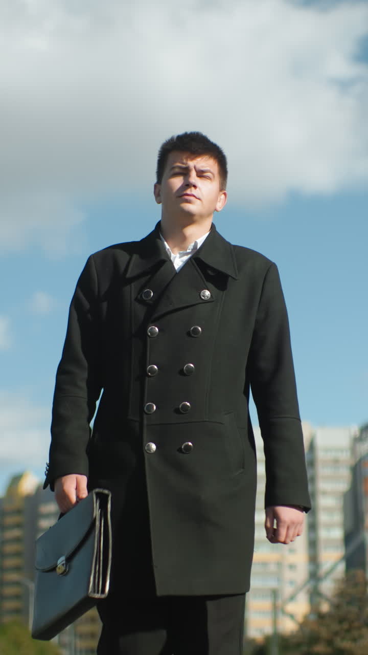 현대적인 도시 건축물, 울창한 초록 나무, 은 파란 하늘에 둘러싸인 브리프케이스를 들고 밖에서 자신감 있게 고 있는 정치인