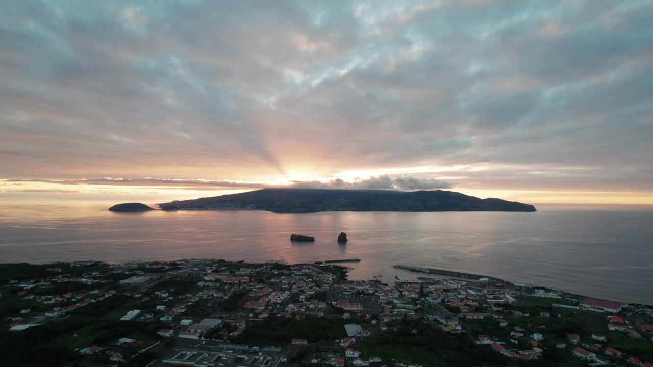 다채로운 해가 지는 하늘과 물 표면에 반사되는 바다 속의 섬들의 아름다운 항공 영상
