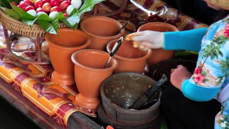 cerca de una mujer haciendo comida tailandesa en el mercado flotante