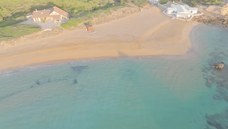 Eine-Atemberaubende-Luftaufnahme-über-Dem-Strand-Von-Cala-Pregonda-Mit-Einigen-Wohngebieten