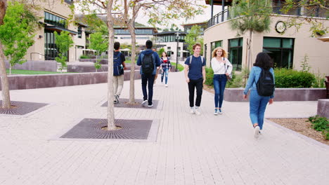 high school students socializing outside college buildings