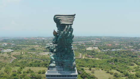 Vista-Lateral-De-La-Enorme-Estatua-De-Cobre-En-Bali,-Indonesia.-Estatua-De-Garuda-Wisnu-Kencana-Que-Se-Eleva-Sobre-La-Ciudad