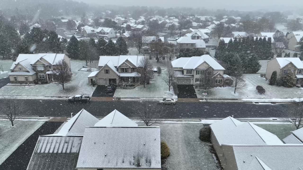 가운 눈보라 아래 두 층짜리 집, 부분적으로 인 도로, 벌거벗은 나무가 있는 교외 거리