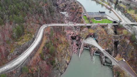 Aerial-dolly-in-shot-of-vehicles-crossing-on-the-corniche-cliffside-Oskarsbron-Oskar-bridge-at-Trollhättan-waterfalls-and-locks-in-Sweden