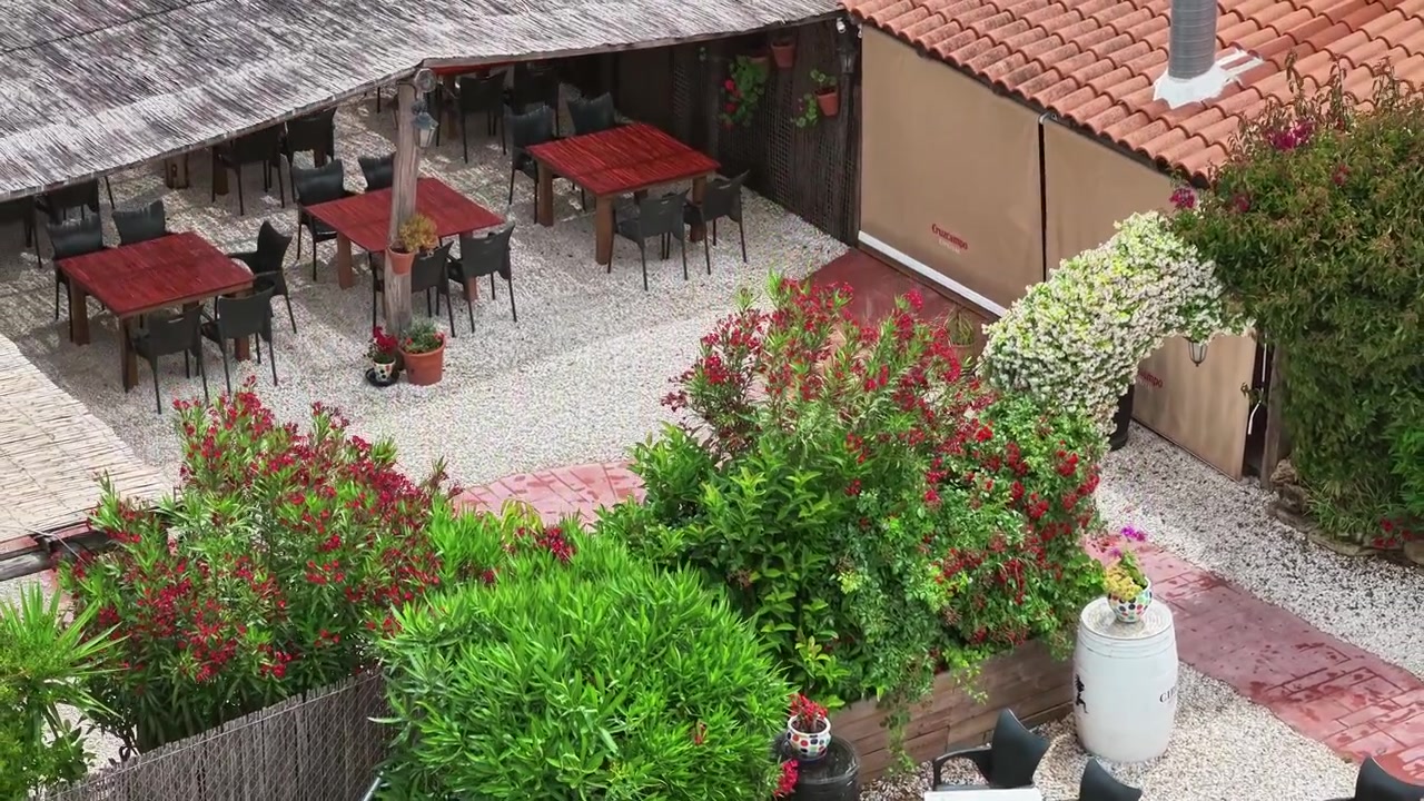 Riprese con drone di un affascinante patio interno a Cadice con forte vento visibile che muove piante e decorazioni esterne.