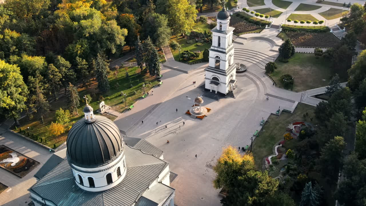 Aerial drone view of Chisinau downtown at sunset. View of central park, Cathedral, bell tower, a lot of greenery, walking people. Moldova