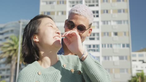 Portrait-of-happy-biracial-couple-embracing-on-promenade,-in-slow-motion