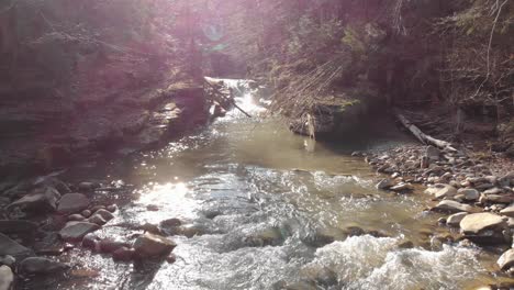 aerial view of a mountain river with beautiful waterfall in the afternoon sunlight