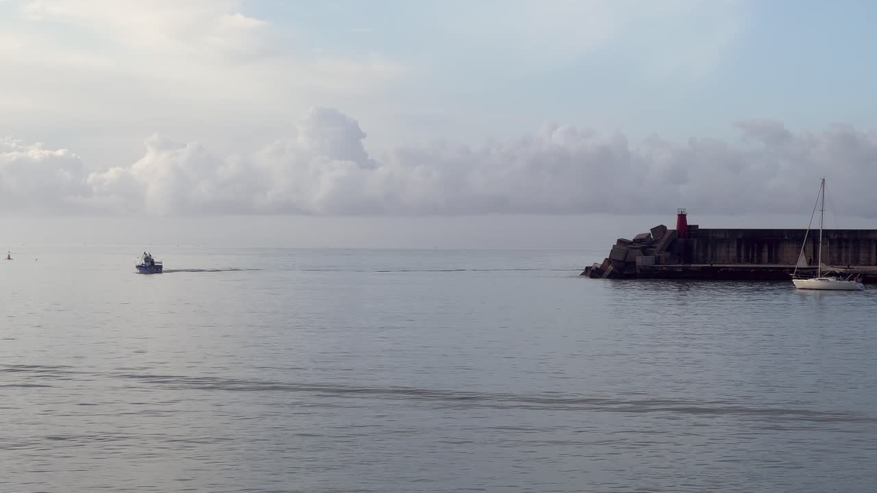 Static view of boats sailing near a lighthouse. Daylight