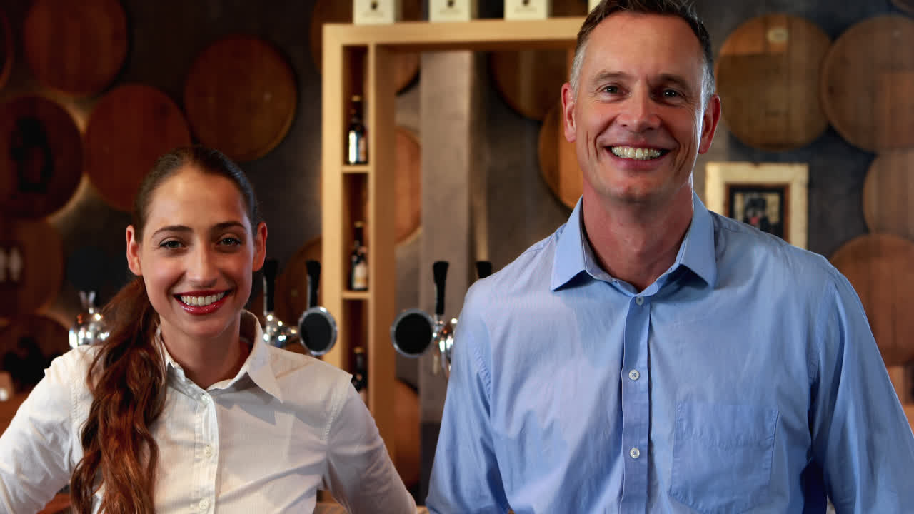 pareja de pie con las manos en la cadera cerca del mostrador de la barra 4k