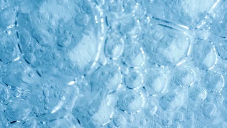burbujas de oxígeno en el agua sobre un fondo abstracto azul en cámara súper lenta.