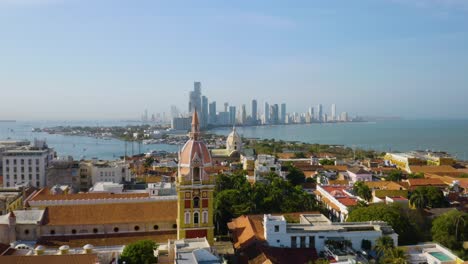 Un-Dron-Sobrevuela-Dos-De-Las-Iglesias-Más-Históricas-De-Cartagena,-Una-Plataforma-Rodante-Se-Dirige-Hacia-El-Horizonte-De-Cartagena