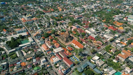 4k cinematic urban drone footage of a panoramic aerial view of the temple of wat chedi luang in the center of the city of chiang mai, thailand on a sunny day