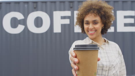 male owner of coffee shop or distribution business by shipping container taking phone call on mobile