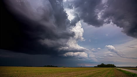 powerful thunder clouds flowing above agriculture landscape, time lapse