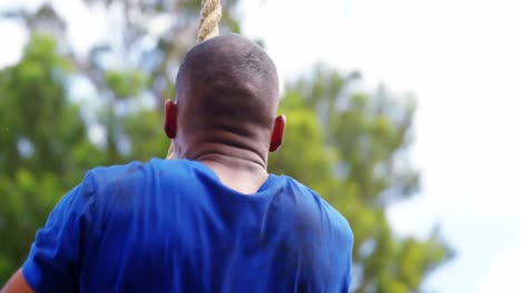 fit man climbing up the rope during obstacle course 4k