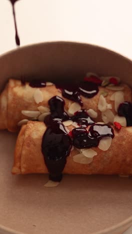 blueberry sauce rolled crepes with almonds and goji berries