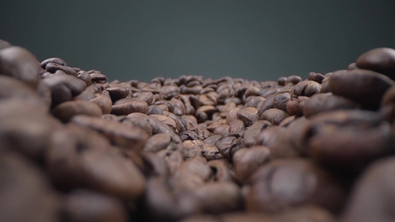 Ripresa macro che si muove attraverso un mucchio di chicchi di caffè tostati