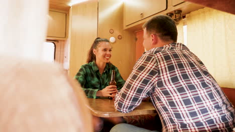 husbnand making his wife laugh while she's holding a bottle of beer