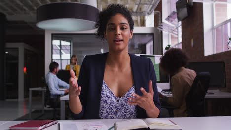 Happy-mixed-race-businesswoman-having-video-call-sitting-in-front-of-computer