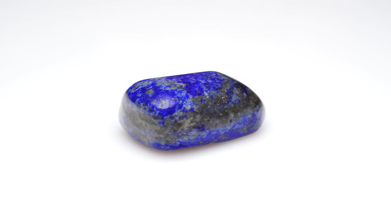 pedra preciosa natural de lapis lazuli no fundo branco na mesa de torneamento