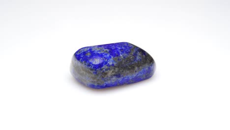 piedra preciosa natural de lapis lazuli en el fondo blanco en la mesa de giro