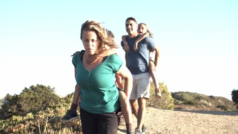 padres activos que cargan a sus hijos y caminan