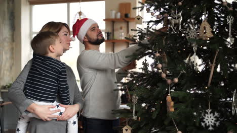 familia decora el árbol de navidad juntos