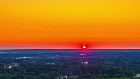 fiery orange sunrise glow over distant farmland and fields, space for text in sky above