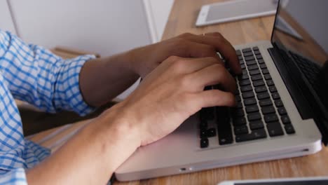 la mano del hombre escribiendo en la computadora portátil