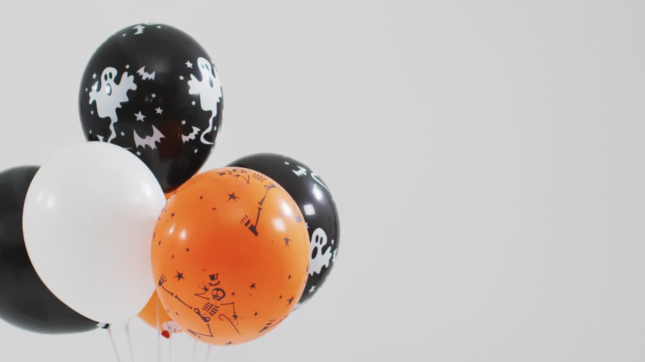 fantasma y esqueleto impreso un montón de globos de halloween contra un fondo gris