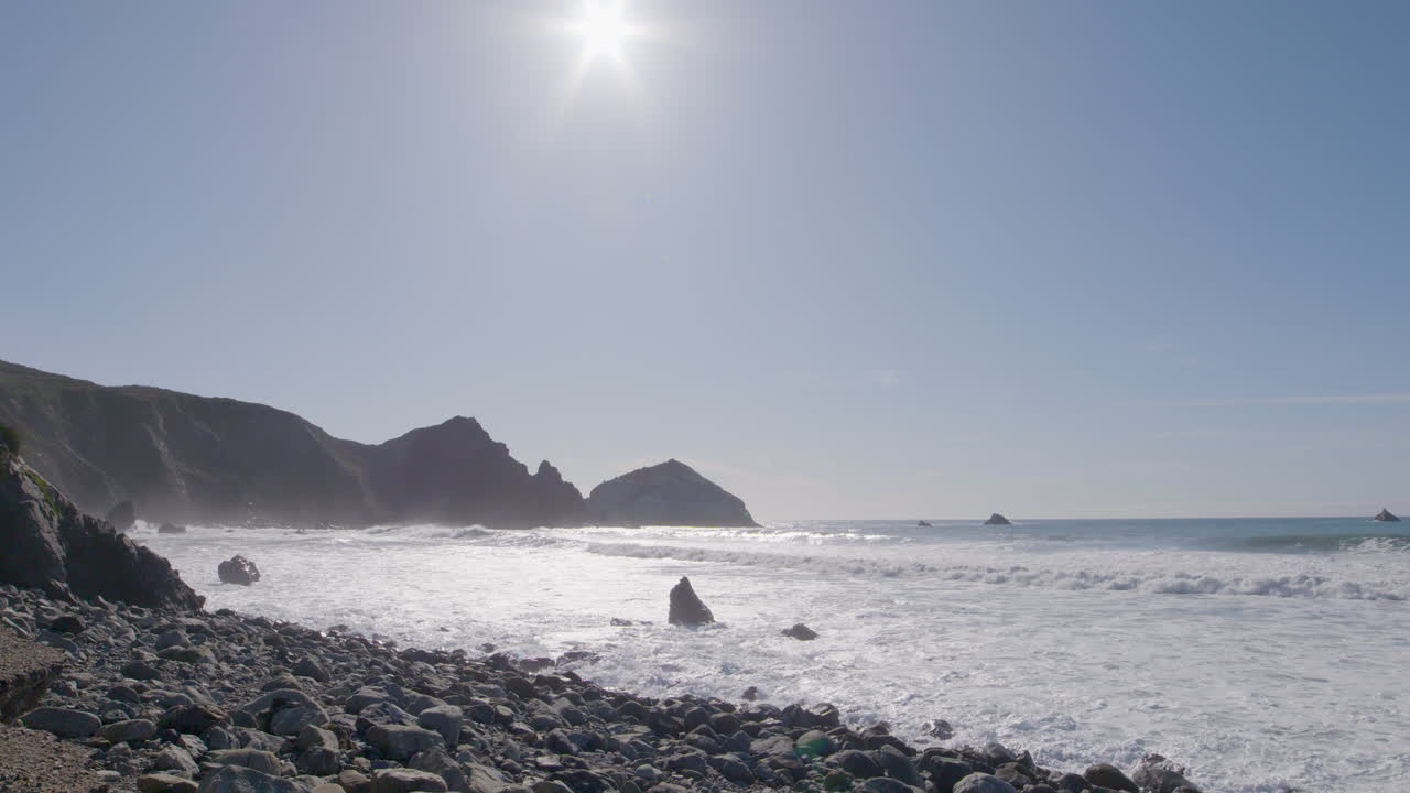 화창한 날 빅서 캘리포니아 해변의 해안으로 부서지는 롤링 파도의 낮은 고정 샷