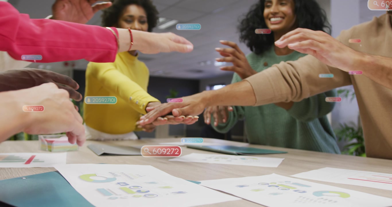 Two women talking business over charts, floating labels overlaying, team stacking hands agreeing